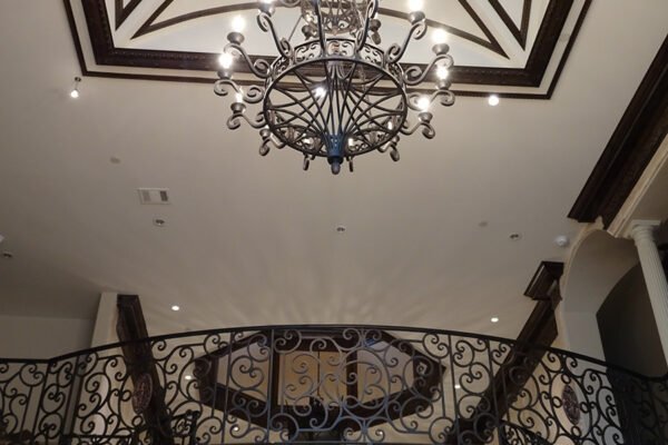 Classic iron chandelier and balcony railing by Solara Custom Living