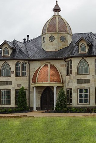 Classic iron doors and lighting chateau exterior by Solara Custom Living