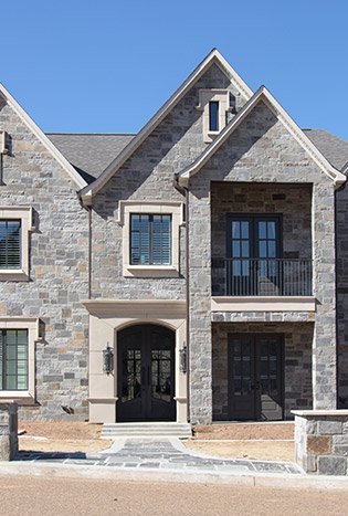 Classic steel entry doors stone tudor home by Solara Custom Living