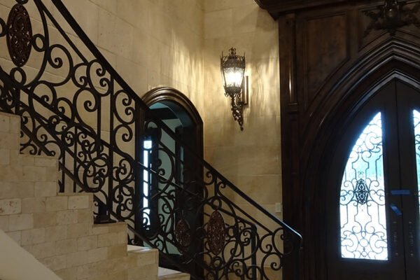 Classic wrought iron curved stair railing foyer by Solara Custom Living