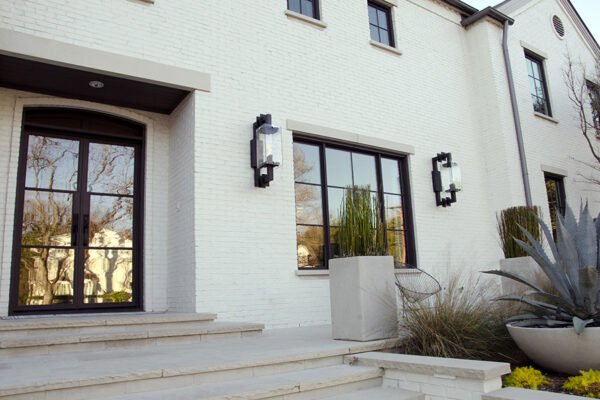 Low profile steel entry door and windows white brick by Solara Custom Living