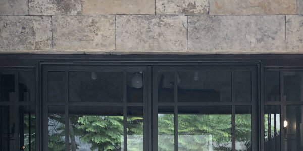 Low profile steel entry door flanked wall sconces by Solara Custom Living