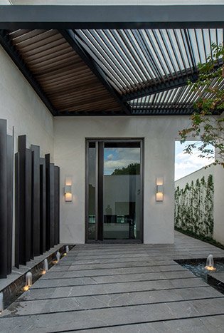 Low profile steel pivot door courtyard walkway by Solara Custom Living