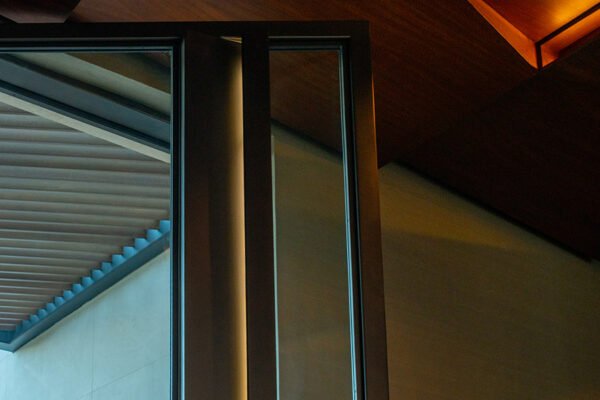 Low profile steel pivot door edge detail by Solara Custom Living