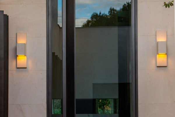 Low profile steel pivot entry door wall sconces by Solara Custom Living