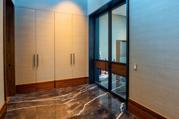 Low profile steel sliding doors marble hallway by Solara Custom Living